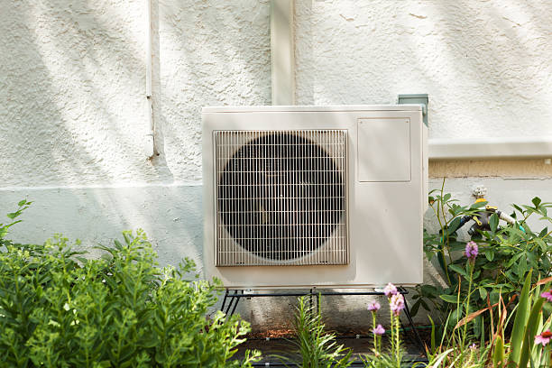 Residential Air Conditioner Heat Exchanger installed Outside a Home Subject: An air conditioner heat exchanger installed in the backyard of a residential home. Air Exchanger stock pictures, royalty-free photos & images