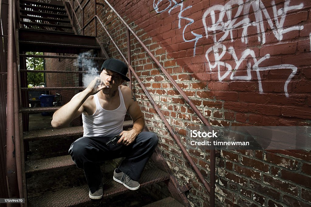 Intimidante Europeo penal y gángster fumar un cigarrillo en Alley - Foto de stock de Acoso escolar libre de derechos