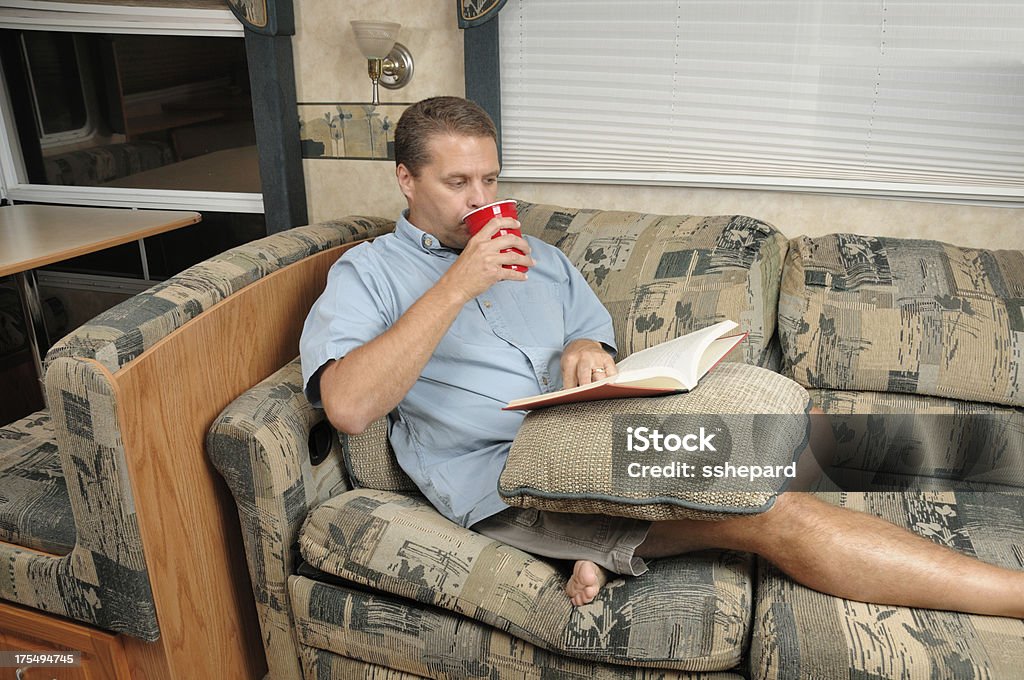 Homem lendo livro e beber em rv - Foto de stock de Adulto royalty-free