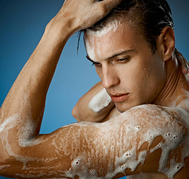 young sexy man having a shower waist up portrait of young  handsome man having a bath shower men falling water soap sud stock pictures, royalty-free photos & images