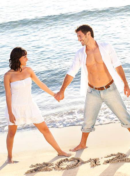 istock couple on beach with the year 2012 written in sand 175495083
