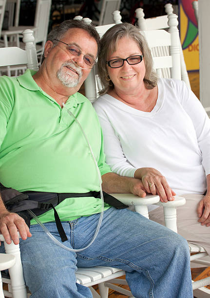 Senior Adult Couple "A full size image of a senior couple, male with oxygen equipment." breathing device stock pictures, royalty-free photos & images