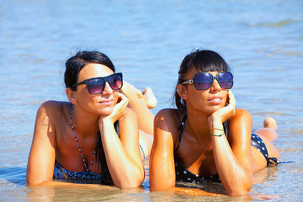 Young woman enjoying summertime in the ocean / sea water.
