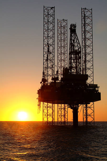 istock Ocean oil rig silhouetted at sunset. 175496600