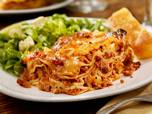 Authentic Italian Meat Lasagna Authentic Italian Meat Lasagna with Ceaser Salad and Foccacia Bread  -Photographed on Hasselblad H3D2-39mb Camera side salad stock pictures, royalty-free photos & images