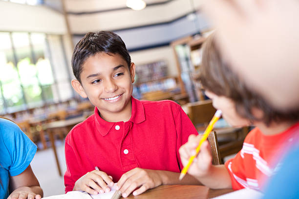 istock Young boy in school library working with fellow students 175497628