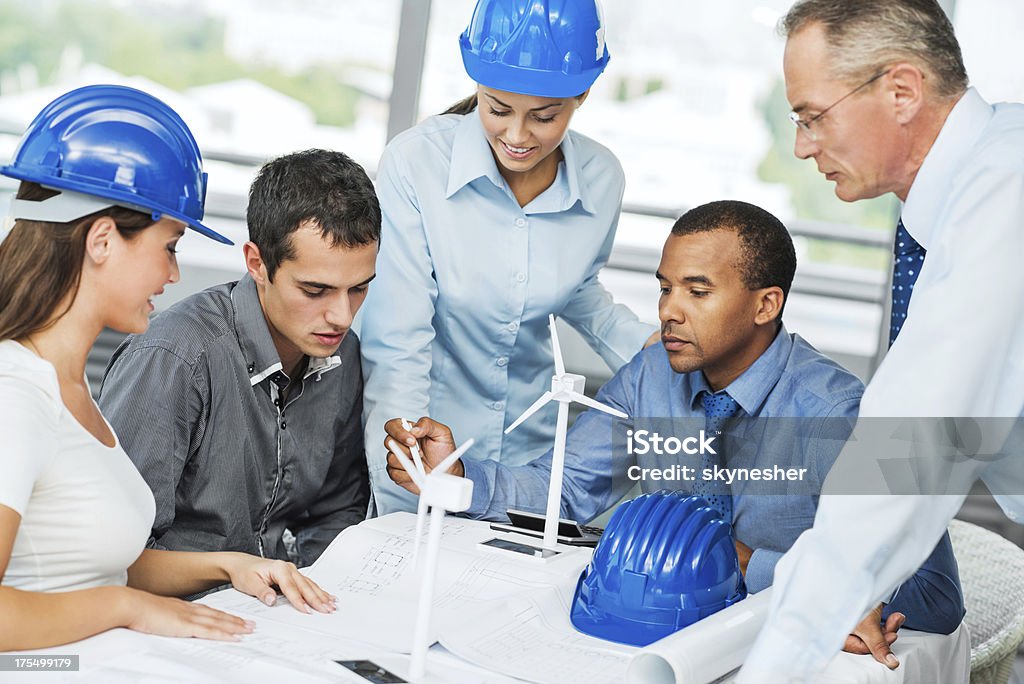 Group of architects working on a Wind Turbine project. Group of successful architects talking about the project regarding the production of Alternative Energy. Men Stock Photo