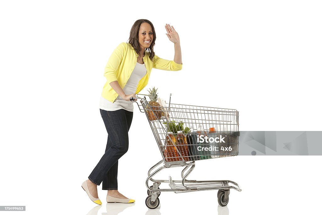 Kobieta pchanie koszyk zakupów w supermarkecie - Zbiór zdjęć royalty-free (Koszyk sklepowy)