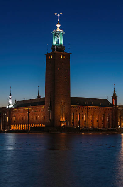 Stockholm Stadshuset City Hall illuminated at night "Stars shining in the deep blue dusk skies over the iconic tower of Stockholm City Hall, Stadshuset, venue for the Nobel Prize banquet, the modern architecture of the downtown Norrmalm waterfront and Central station reflecting in the still waters of Riddarfjarden, Stockholm, Sweden. ProPhoto RGB profile for maximum color fidelity and gamut." kungsholmen town hall photos stock pictures, royalty-free photos & images