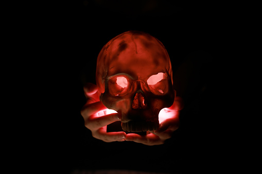 Red light illuminates the skull. Halloween concept