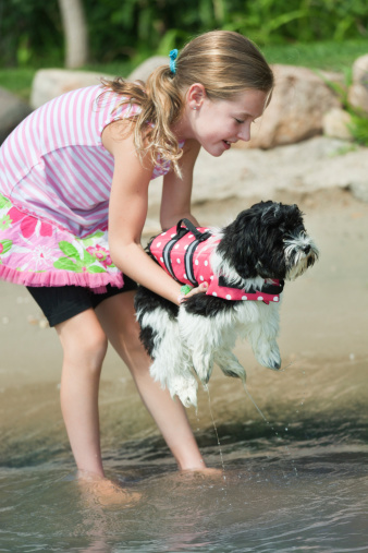 Subject: Children playing with family pet dog by the lake.