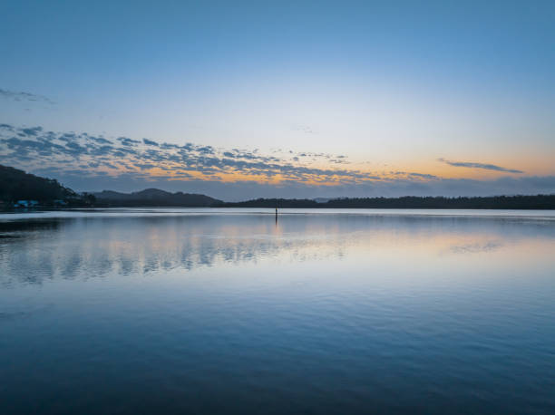 istock Sunrise waterscape with a scattering of clouds and reflections 1755010790