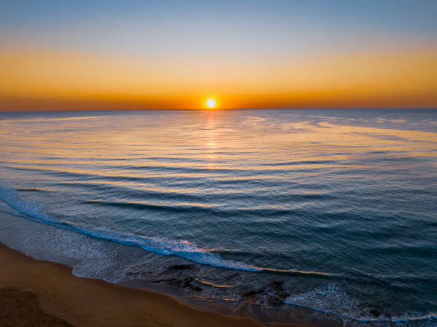 istock Aerial sunrise seascape with a hazy sky from fire reduction burnoffs 1755011115
