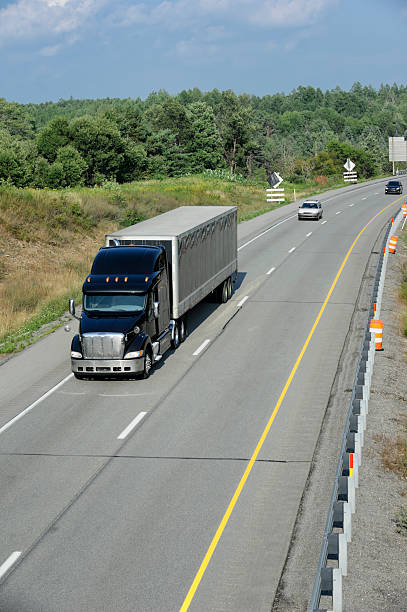 istock Trucks Moving on Highway, American Interstate in Afternoon Sunlight 175501136