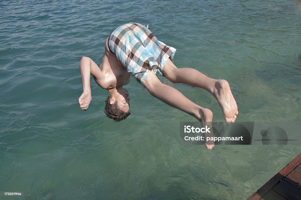Ragazzo adolescente nel bel mezzo di una Capriola in acqua - Foto stock royalty-free di Acqua