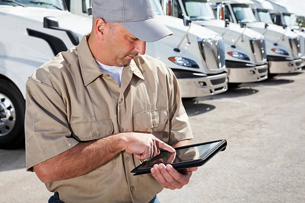 istock Truck driver in front of big rigs with digital tablet 175502977