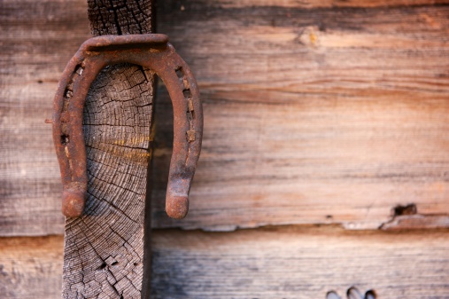rusty iron horse shoe on the wooden background