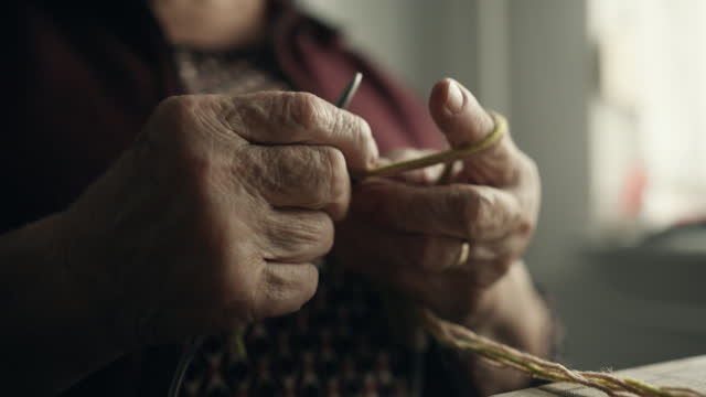 Closeup of Hands of Elderly Woman Knitting at Home