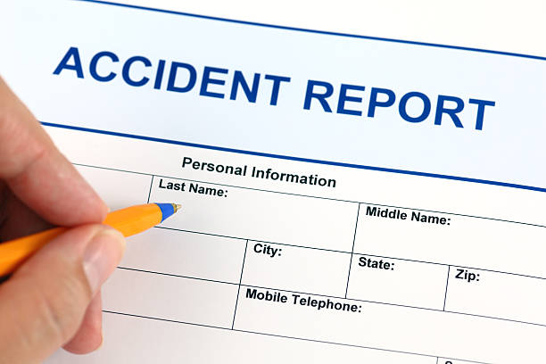 Yellow pen filling out an accident report form stock photo