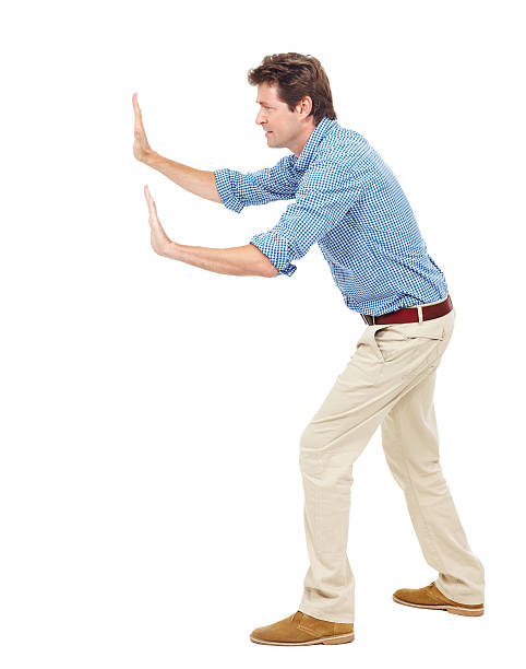 Pushing the boundaries Casually dressed male pushing against an invisible wall - isolated mime artist stock pictures, royalty-free photos & images