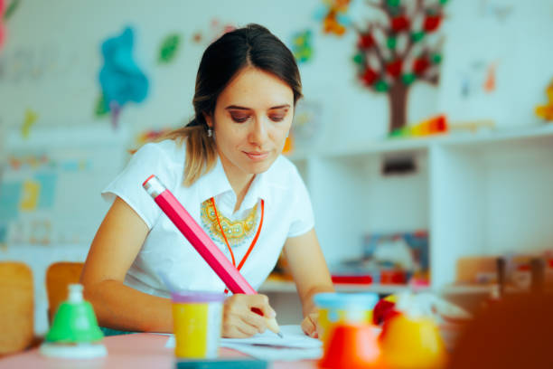 istock Preschool Teacher Writing with a Big Pencil on a Paper 1755045704