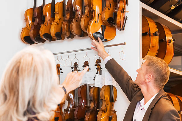 女性顧客/バイイングバイオリンを演奏 - music store ストックフォトと画像