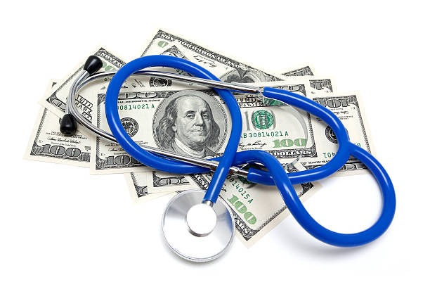 stetoscopio su dollari usa - currency stethoscope healthcare and medicine savings foto e immagini stock
