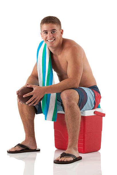 привлекательный молодой человек, сидящий на ледяной box - male swimwear cooler 20s стоковые фото и изо�бражения