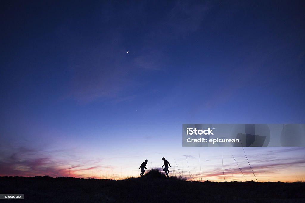 Dos hombres s'ofrecen motos acuáticas y disfrutar de una ejecución de capacitación al atardecer - Foto de stock de Escena rural libre de derechos