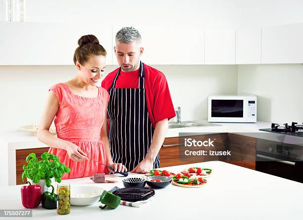 Happy Young Couple Making Pizza Stock Photo - Download Image Now - 20-24 Years, 30-34 Years, Adult