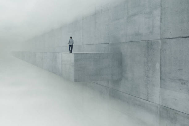 istock Surreal image of man walking high up on the concrete ledge 1755073035