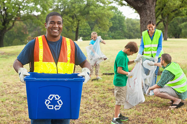 istock Friendly volunteer collecting garbage and recycling with team in park 175507377