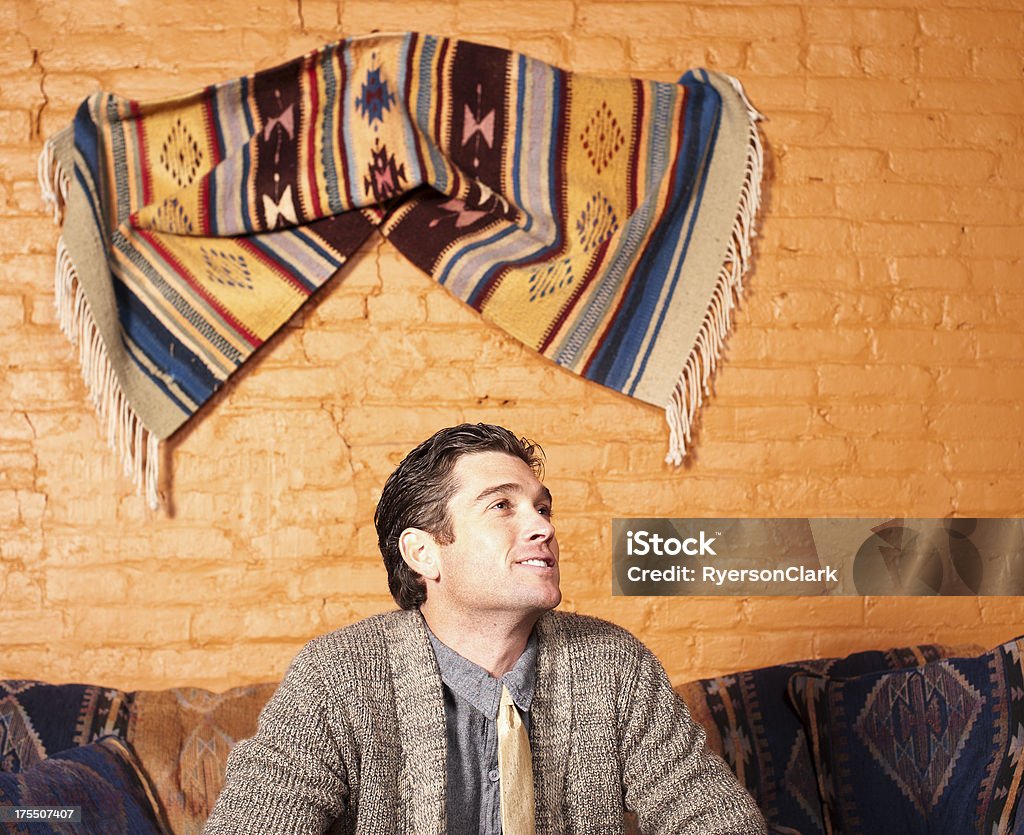 Hombre en el sofá con motivos del sudoeste de Estados Unidos. - Foto de stock de 20 a 29 años libre de derechos