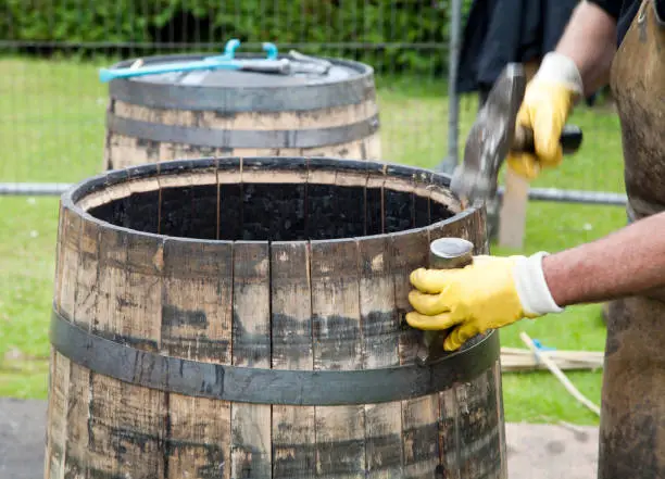 A cooper demonstrates the construction of a whisky barrel