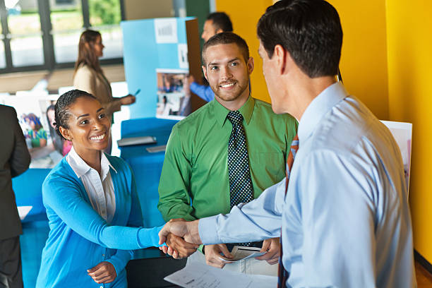 Professional business team shaking hands with businessman at job fair Professional business team shaking hands with businessman at job fair job fair photos stock pictures, royalty-free photos & images