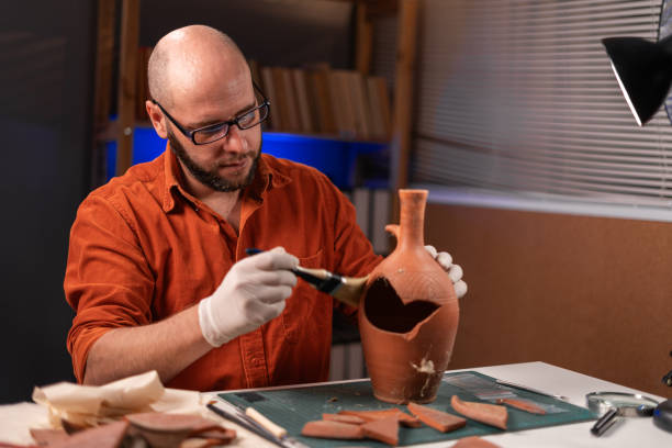 istock Bearded archaeologist with glasses working in office late at night 1755085049