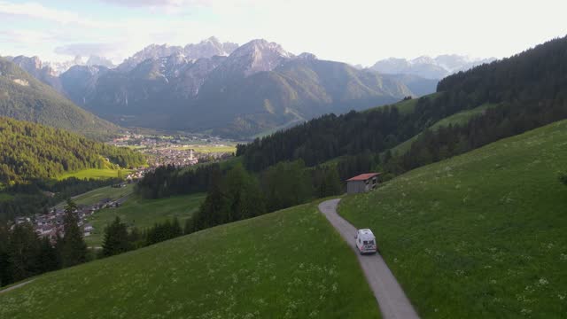 A camper van explores the outskirts of Toblach, Italy in this drone shot