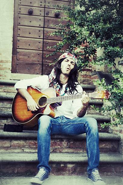 hippy mężczyzna gra na gitarze śpiewać i - playing an instrument vertical blurred motion outdoors zdjęcia i obrazy z banku zdjęć