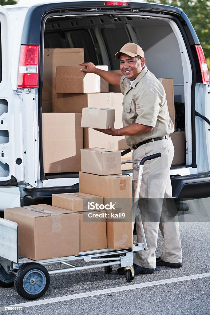 Hispanic man delivering packages Hispanic man (40s) with delivery van full of cardboard boxes. Box - Container Stock Photo