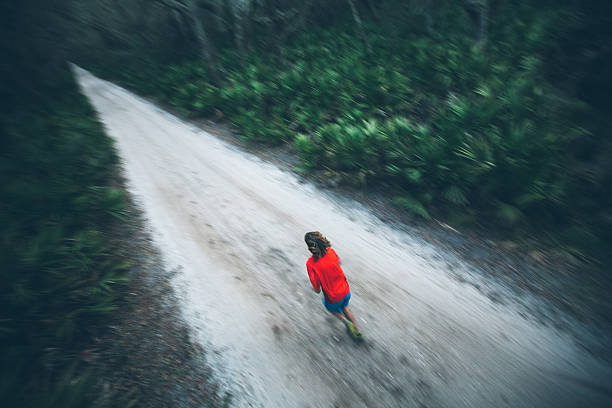 istock Solitary male runs under trees on road at sunset 175509872