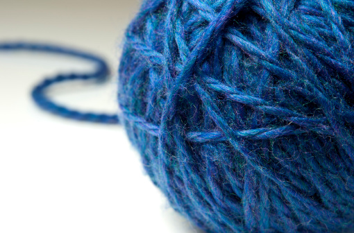 Ball of blue wool or yarn on a white background