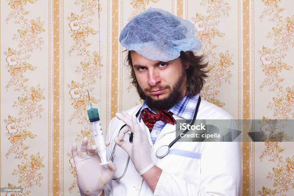 Crazy scientist Portrait of crazy scientist holding big syringe in one hand. Doctor Stock Photo