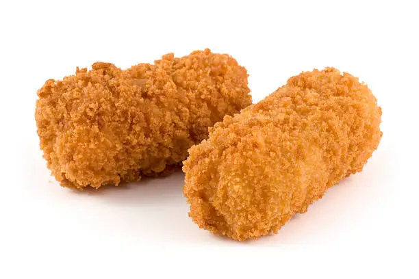 "Two Croquettes on a white background. Main focus around the font of the first croquette, softer focus towards the second croquette."