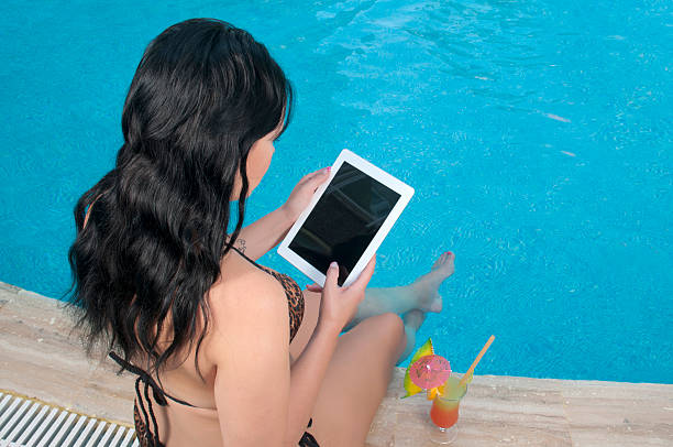 istock Young woman using digital tablet by the pool 175513843