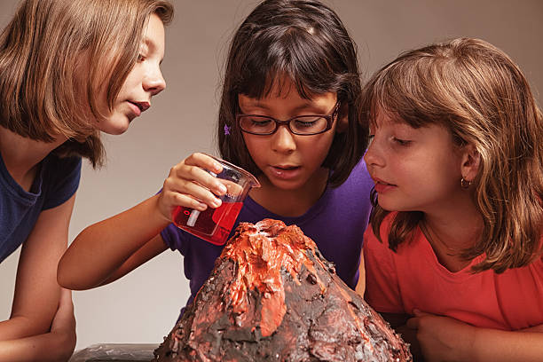 science fair project Little girls make their volcano science project erupt. science fair volcano stock pictures, royalty-free photos & images