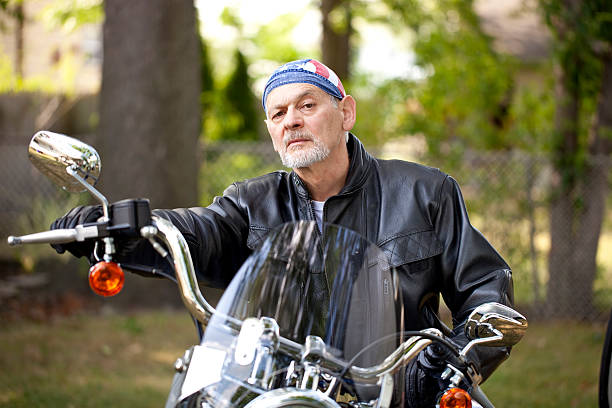 Biker with tough look on a motorcycle with a menacing stare Biker with beard and tough look sitting on a motorcycle looking at camera with a menacing stare. Image shot with, Canon 5D Mark2, 100 ISO, 24-115mm lens do rag stock pictures, royalty-free photos & images
