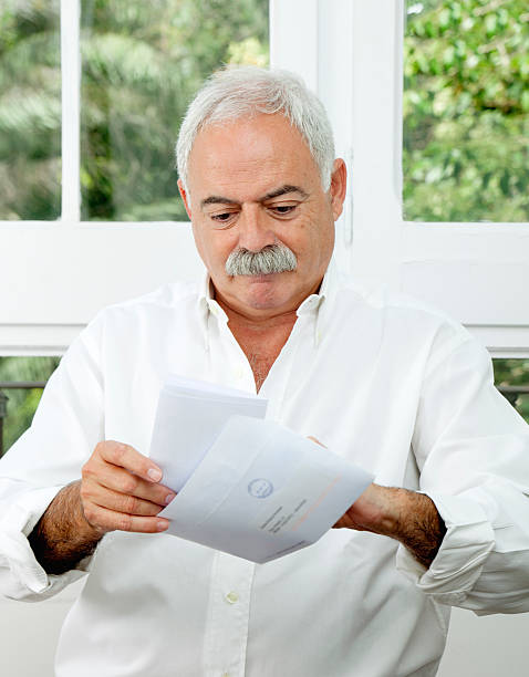 istock Senior man opening a letter 175514686