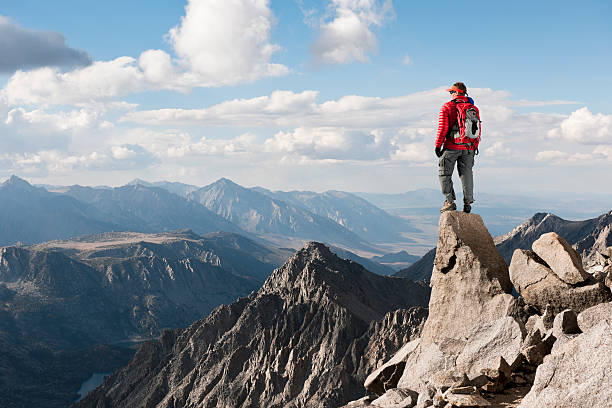 Mountains A man on top of a mountain looking at view  mountaineering stock pictures, royalty-free photos & images