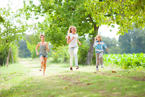 istock Mummy and kids running on green meadow 175515914