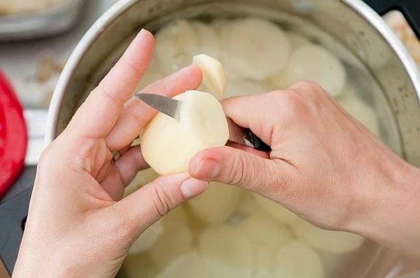 Young Woman Cutting Potatoes